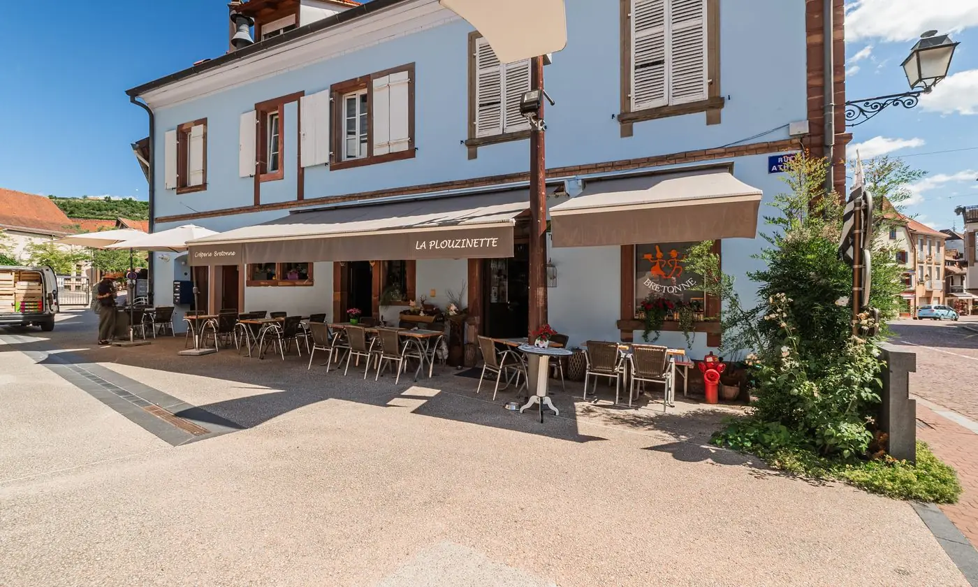 La façade bleu clair de La Plouzinette et sa terrasse